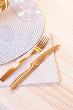 Tenedor y cuchillo dorados sobre una servilleta