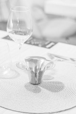 Copa y portavelas sobre un bajoplato, en blanco y negro