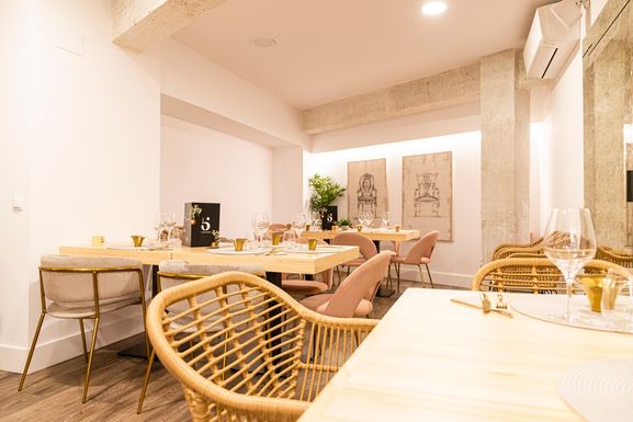Comedor con sillas de mimbre y las mesas puestas
