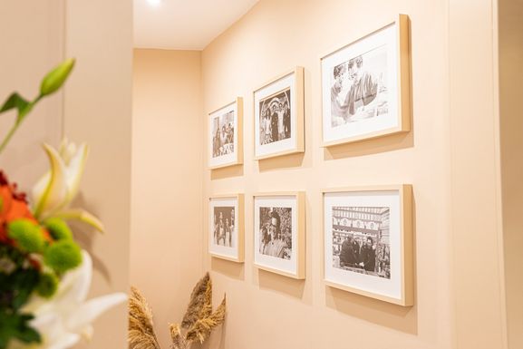 Pared con fotografías enmarcadas en blanco y negro y un ramo de flores