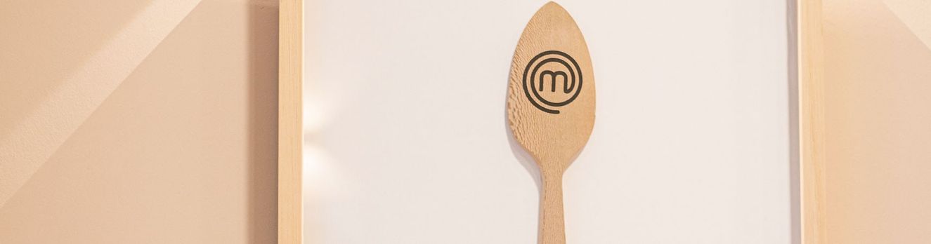 Cuchara de madera con el logo de Masterchef, enmarcada en la pared